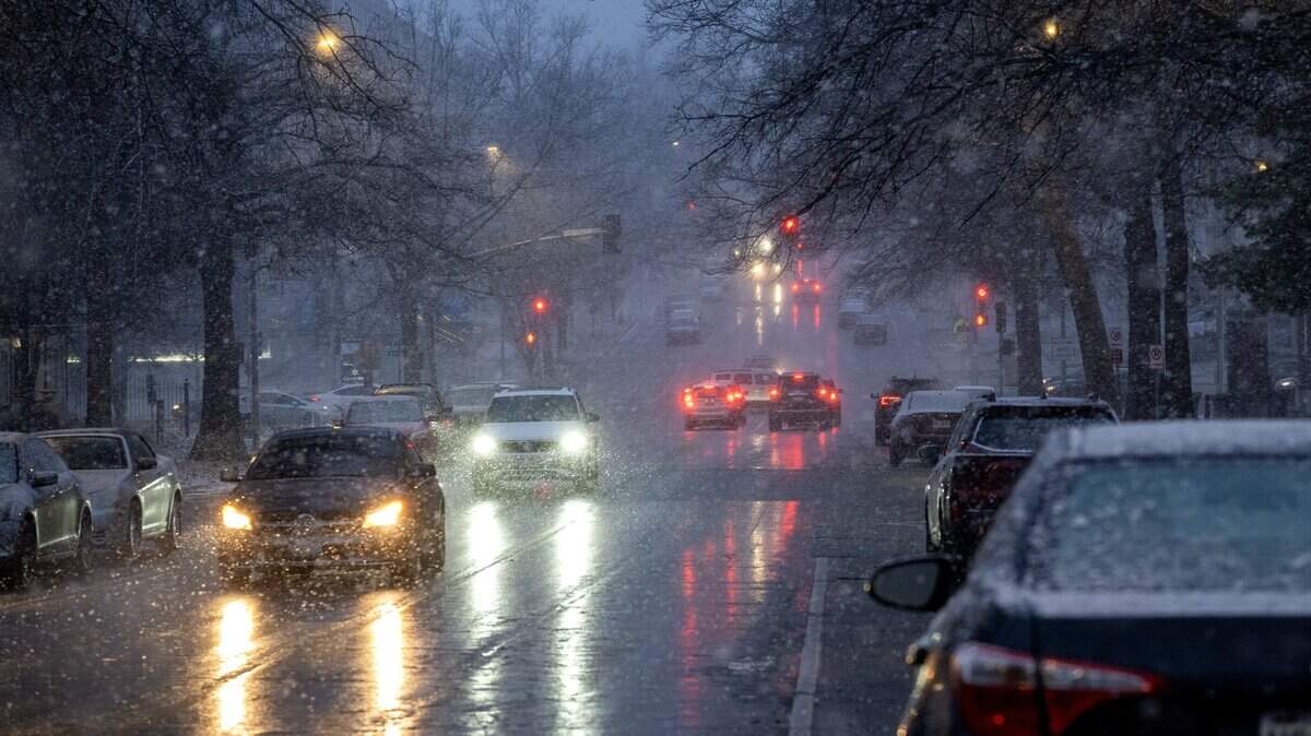 Vehicles drive as light snow begins to fall on Friday, Jan. 16, 2026, in Kansas City.