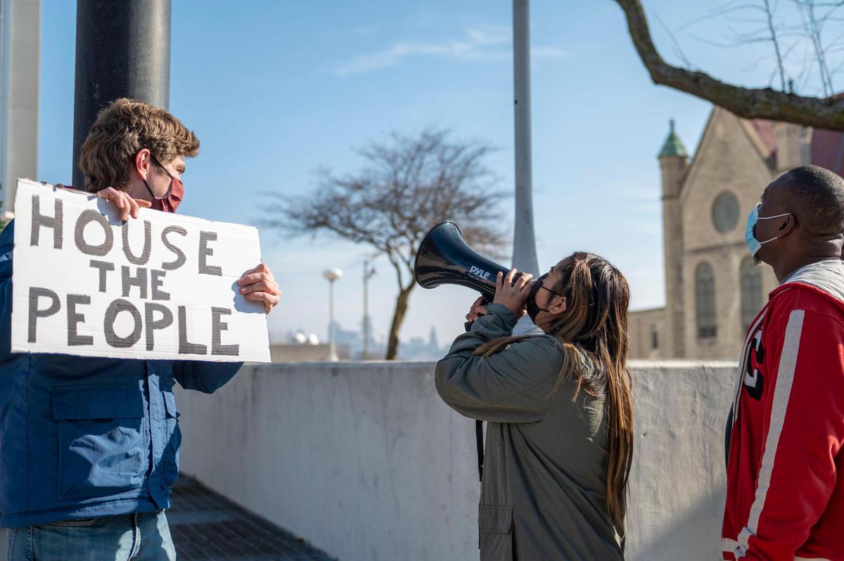 Community organizer Yasmine Bruno-Valdez, center, used a megaphone to call on Mayor Tyrone Garner to open the extreme cold weather shelter Thursday during a protest outside of Wyandotte County Unified Government headquarters in Kansas City, Kansas.