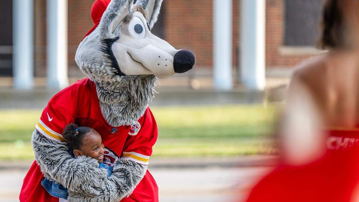 Seven-year-old Kam Brown spots mascot K.C. Wolf and gives him a hug while dropping off her sister with grandma Wendy Mitchem for the first day of school at Central Middle School on Monday, Aug. 19, 2024, in Kansas City.
