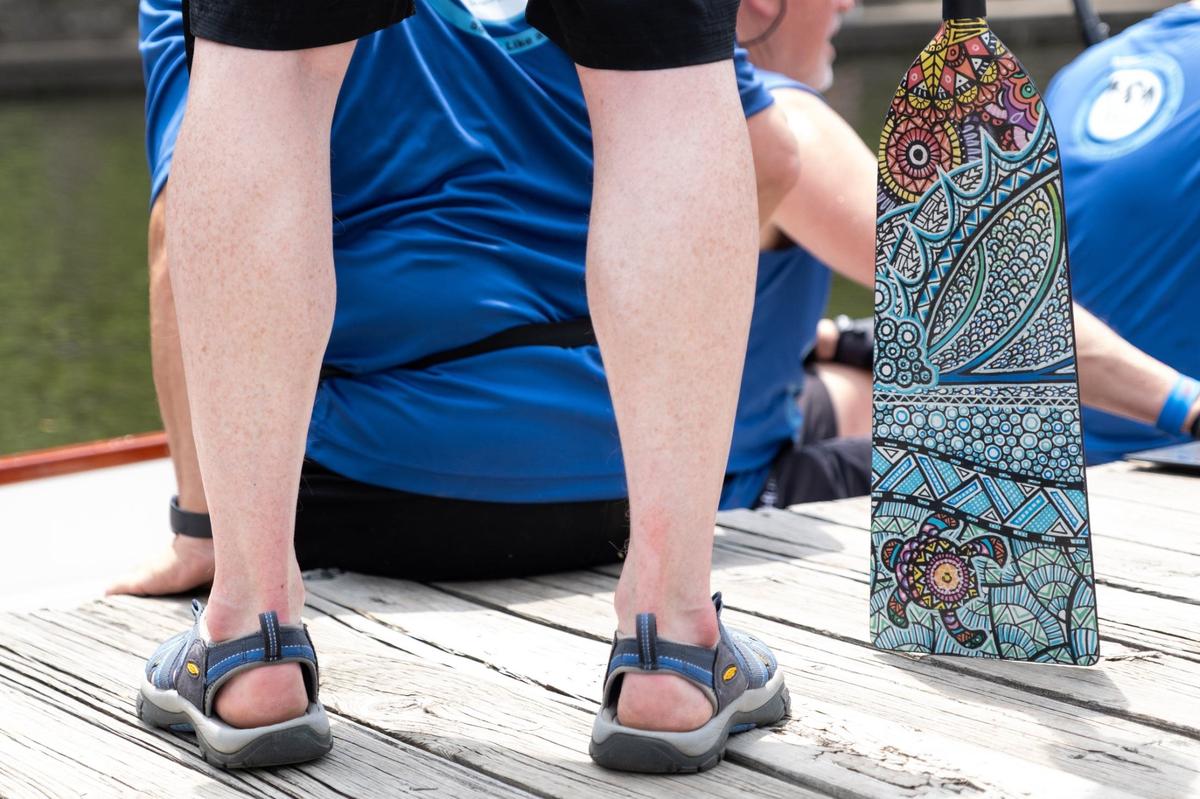 A SLAP Dragons team member waits to board a boat with a bright paisley patterned paddle during the 18th annual Kansas City Dragon Boat Festival.
