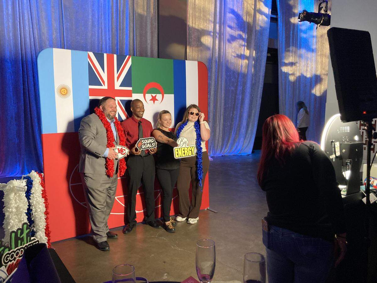 Visitors pose for photos in front of World Cup team flags at Visit KC’s annual event, held Thursday, May 7, at Municipal Auditorium.