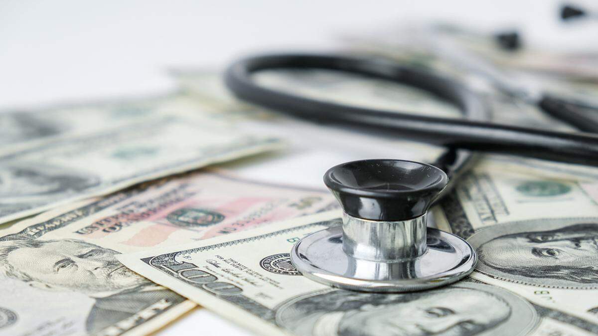 Stack of cash dollars and stethoscope. 
