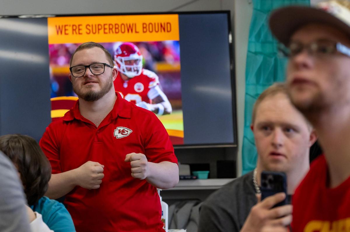 Students from left, Matt Horn, Ted Clayton, and Jacob Tomandl look on as Chiefs tight end Noah Gray talks to the group during a visit to PawsAbilities on Wednesday.