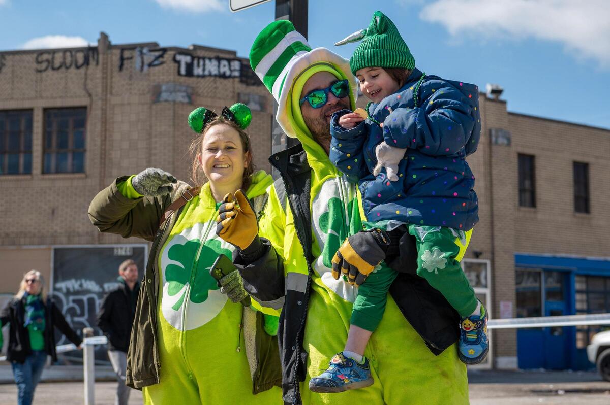 Lauren MacPherson, left, John MacPherson and their daughter Cassidy wave to parade watchers during the Kansas City St. Patrick’s Day parade on Friday, March 17, 2023, in Kansas City.