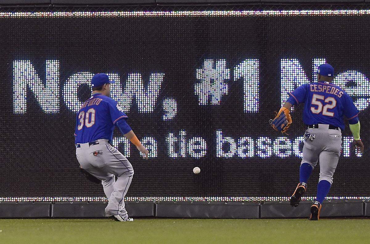 New York Mets left fielder Michael Conforto, left, and center fielder Yoenis Cespedes scramble to chase down a ball hit by Kansas City Royals shortstop Alcides Escobar in the first inning for an inside the park home run during Game 1 of the World Series on Tuesday, October 27, 2015 at Kauffman Stadium in Kansas City, Mo.