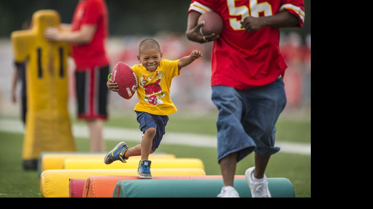 Marcel Griffin, 3, of Grandview ran with his father, Mario, in Family Fun Day activities on Saturday morning during the Chiefs summer training camp at Missouri Western State University in St. Joseph.