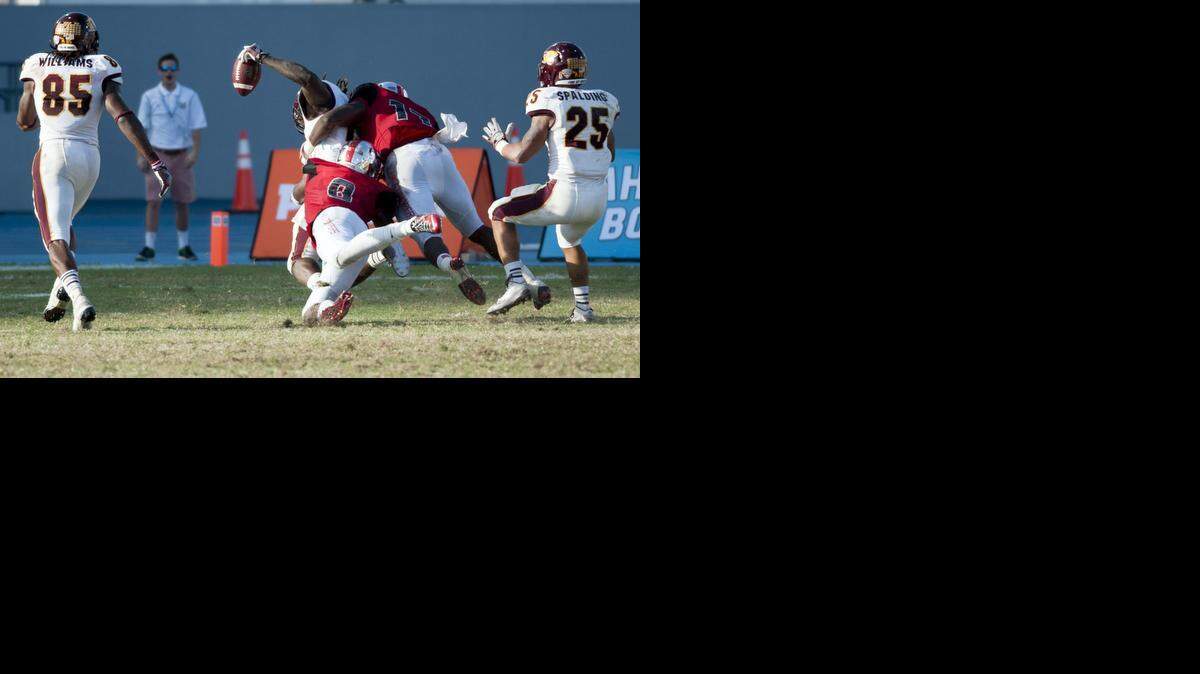 
Central Michigan Chippewas tight end Deon Butler laterals the ball to wide receiver Courtney Williams, left, while being tackled by Western Kentucky linebacker Dejon Brown and defensive back Marcus Ward during the Bahamas Bowl NCAA college football game, Wednesday, Dec. 24, 2014, in Nassau, Bahamas. (AP Photo/The Daily News, Austin Anthony)

