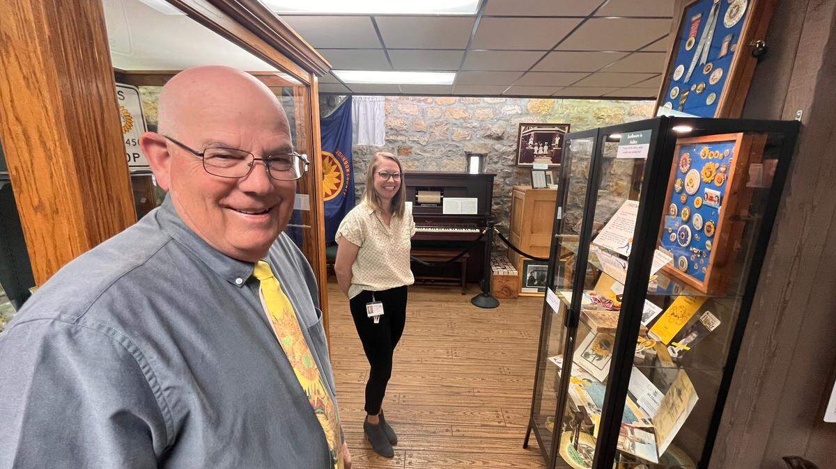 Bill Nicks, collector, and Ashley Nguyen, recreation supervisor of history with the city of Lenexa’s Parks & Recreation Department, stand amid Nicks’ sunflower collection. The collection is on display at Legler Barn & Museum.