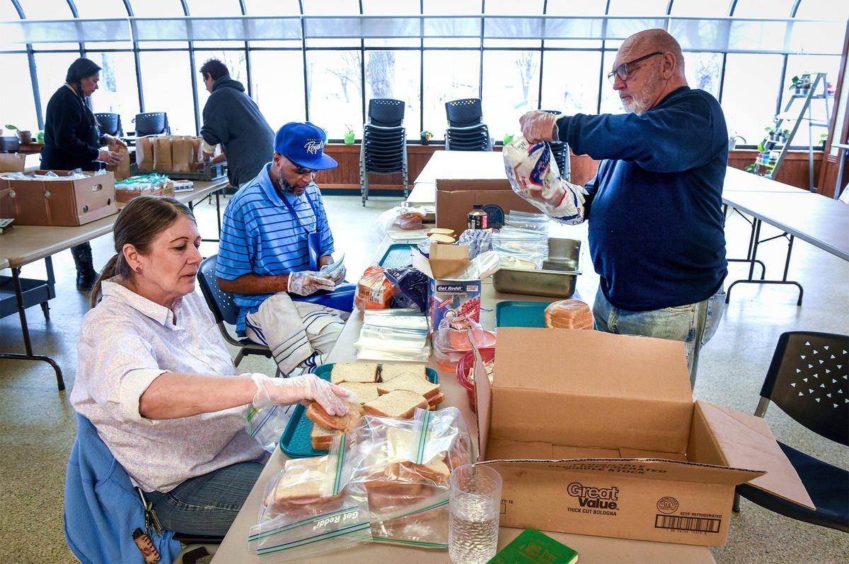 Volunteers including Jane Wilson, from left, Anthony Bush and David Atwell made sandwiches to be distributed to those in need at the Cross-Lines Community Kitchen in Kansas City, Kansas.