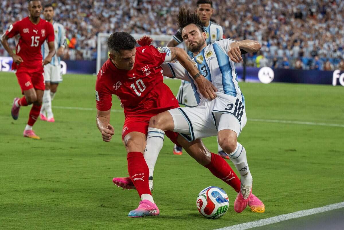 Switzerland midfielder Granit Xhaka (10) fights for the ball against Argentina defender Nicolás Tagliafico (3) in a 2026 FIFA World Cup quarterfinal match at Kansas City (Arrowhead) Stadium in Kansas City on Saturday, July 11, 2026.