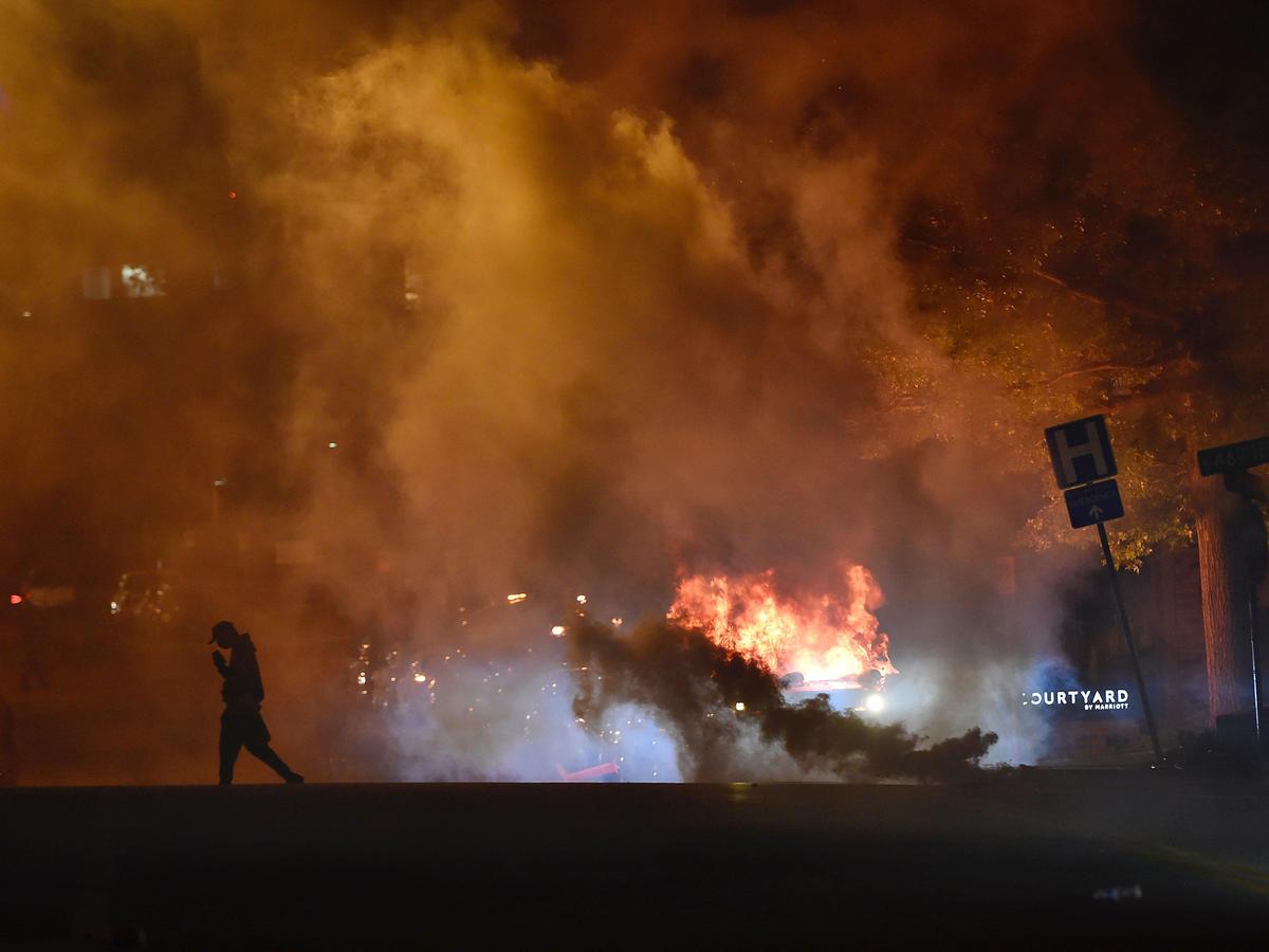 A Kansas City Police Department police car burns after a protester set it on fire during protests Saturday night at the Country Club Plaza. A protest meant to bring awareness to the death of George Floyd while in custody of Minneapolis police turned violent when stores and the police car became targets.
