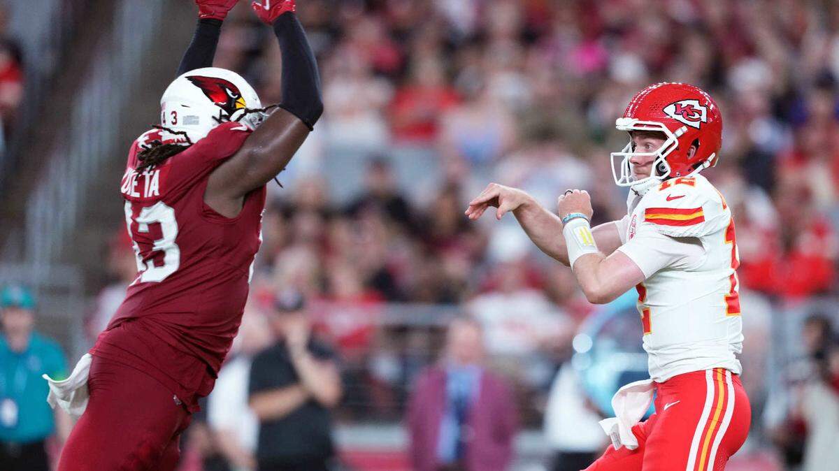 Kansas City Chiefs quarterback Shane Buechele (12) throws the ball by Arizona Cardinals linebacker Jesse Luketa (43) during the first half at State Farm Stadium on Aug. 19, 2023.
