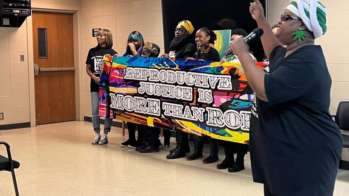 Justice Gaston and other organizers with the Reale Justice Network hold a banner at a reproductive justice rally in Kansas City on Sunday.