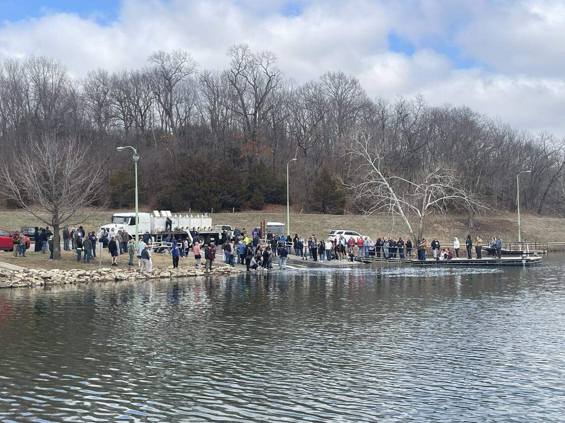 Wyandotte County residents, government staff and media gather to watch officials feed Rainbow trout into Wyandotte County Lake Park on the afternoon of March 5, 2026.