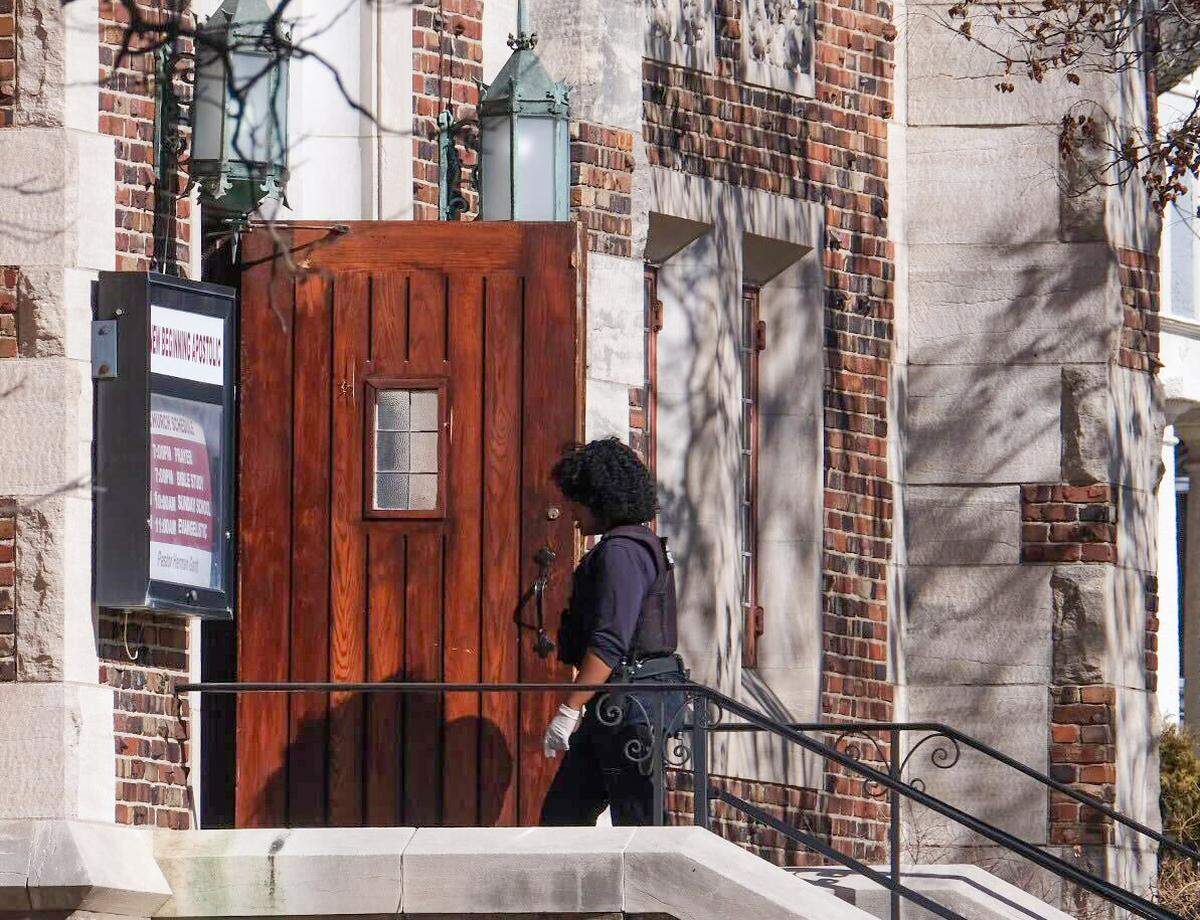 A police investigator walks into New Beginning Apostolic Church at 200 N. Bales Ave. in Kansas City’s Scarritt Renaissance neighborhood Friday after a shooting during a funeral service injured four people.