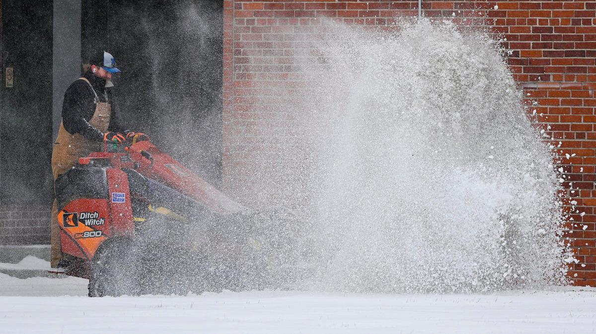 Zach Leifried with Embassy Landscape Group braced himself against the blowback of snow as he worked to clear paths around buildings in North Kansas City. Two to four inches of snow fell in the Kansas City area Saturday morning, Jan. 15, 2022.