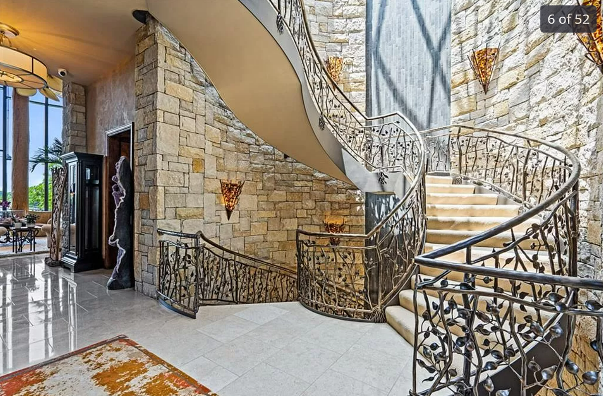 Intricate masonry, glass wall sconces and ironwork are seen in the foyer of the mansion at 472 N Winnebago Drive in Lake Winnebago, Missouri.