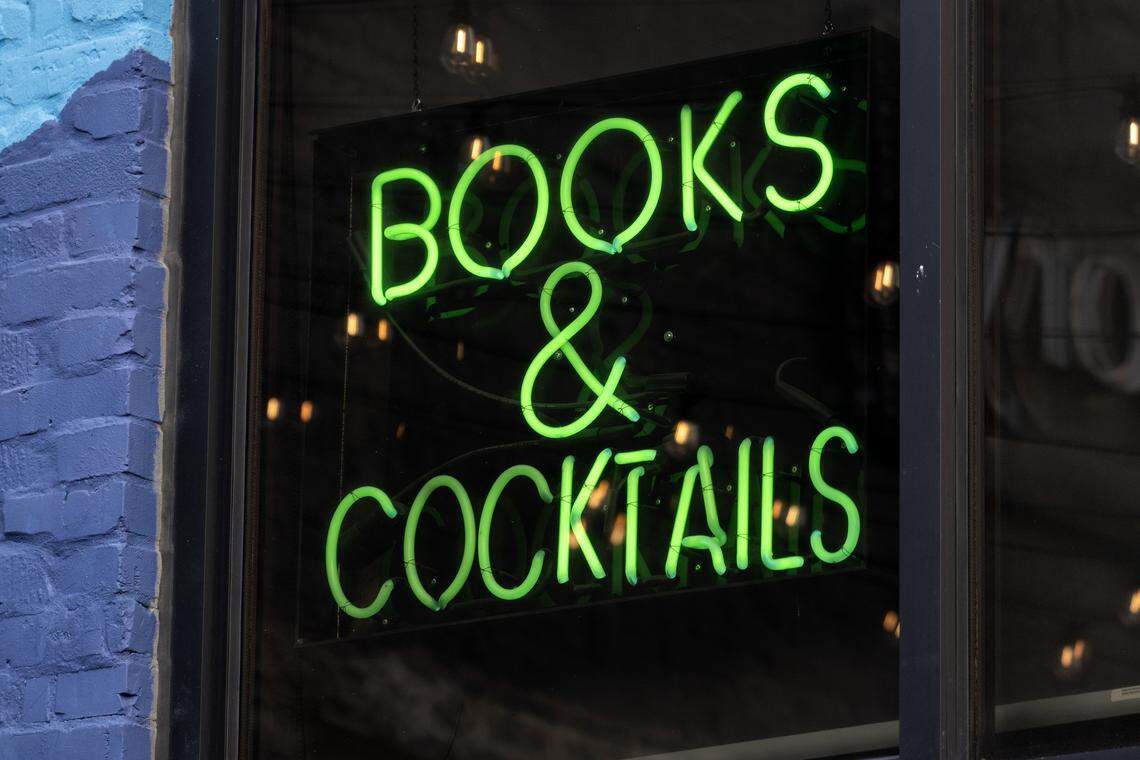 A neon sign reading “Books & Cocktails” is displayed at the back entrance of Afterword on Wednesday, Dec. 3, 2025, in Kansas City.