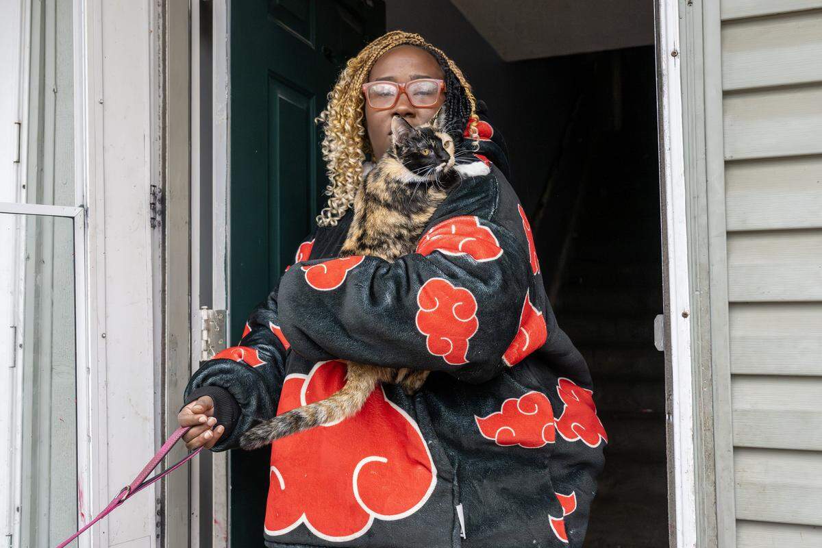 Passion Paris, a resident of Olive Park Village Apartments, holds her cat as she discusses her living experience on Friday, Nov. 21, 2025, in Kansas City.