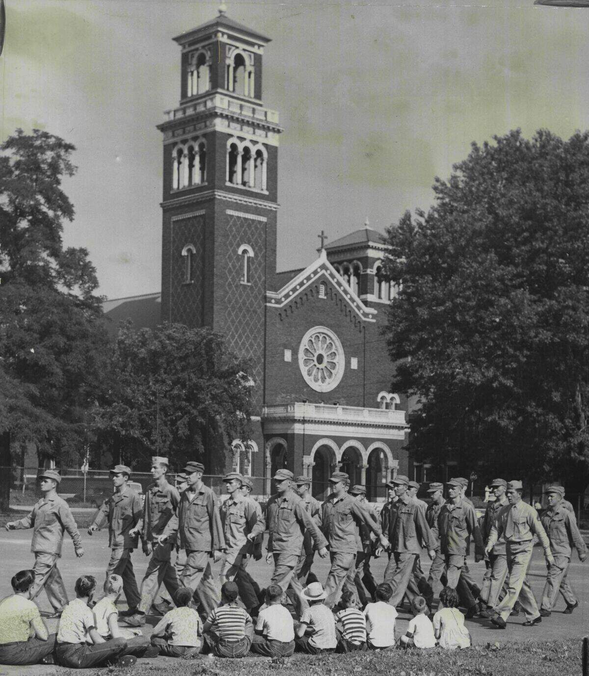 In 1950, Marine recruits marched in front of a group of neighborhood children outside of Our Lady of Sorrows Catholic Church.