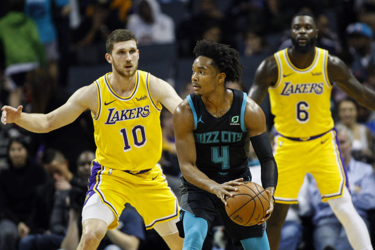 Charlotte Hornets guard Devonte’ Graham (4) looks to pass against Los Angeles Lakers guard Sviatoslav Mykhailiuk, right, and guard Lance Stephenson in the second half of an NBA basketball game in Charlotte, N.C., Saturday, Dec. 15, 2018. Los Angeles won 128-100. (AP Photo/Nell Redmond)