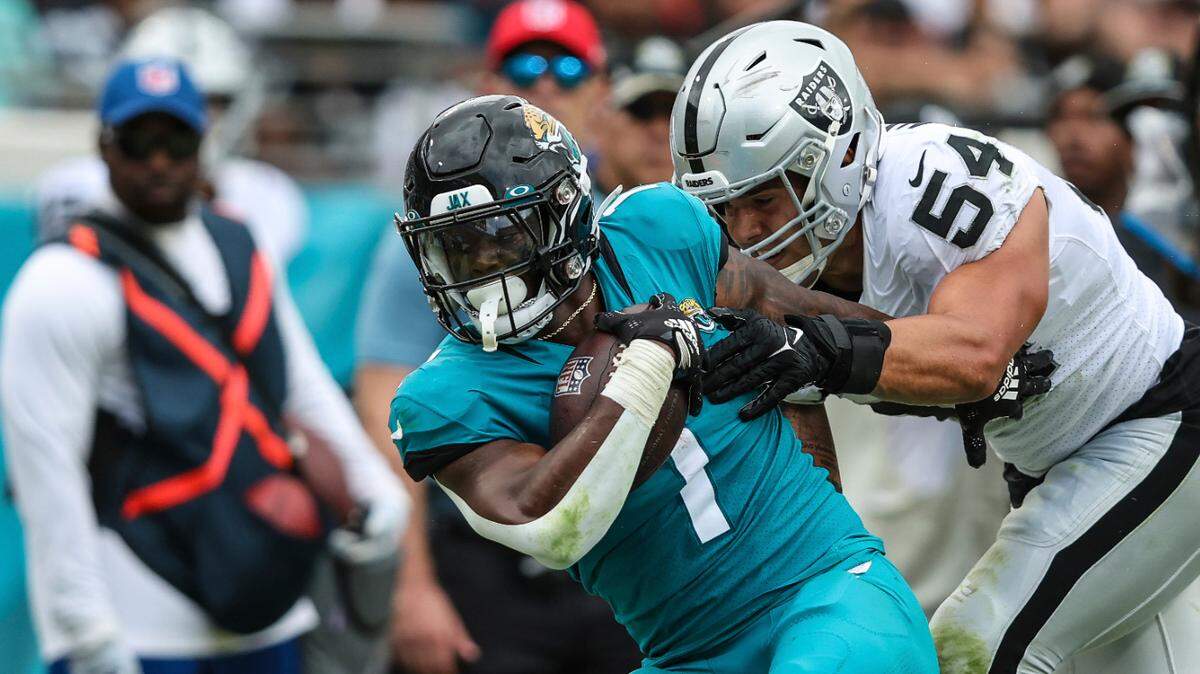 After a catch Jacksonville Jaguars running back Travis Etienne Jr. (1) is tackled by Las Vegas Raiders linebacker Blake Martinez (54) during an NFL football game on Sunday, Nov. 6, 2022, in Jacksonville, Fla. (AP Photo/Gary McCullough)