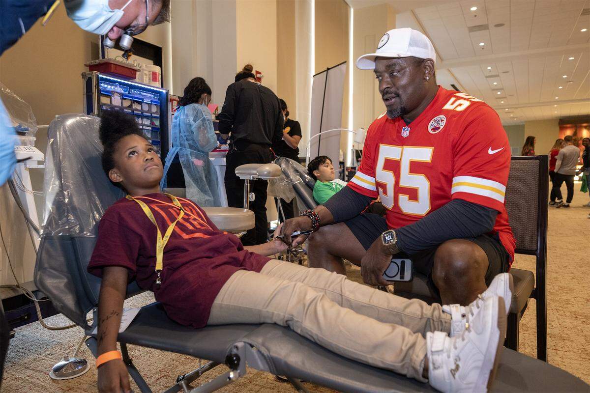 Former Kansas City Chiefs player Gary Stills holds the hand of Deonna Jones, 7, of Kansas City, before she had some free dental work done during the TeamSmile dental tailgate on Tuesday, Sept. 9, 2025 at GEHA Field at Arrowhead Stadium. More than 200 volunteer dentists, hygienists, and dental assistants, backed by TeamSmile and the Chiefs, provided free dental care to 300 children from Kansas City, Missouri, and Kansas City, Kansas schools.