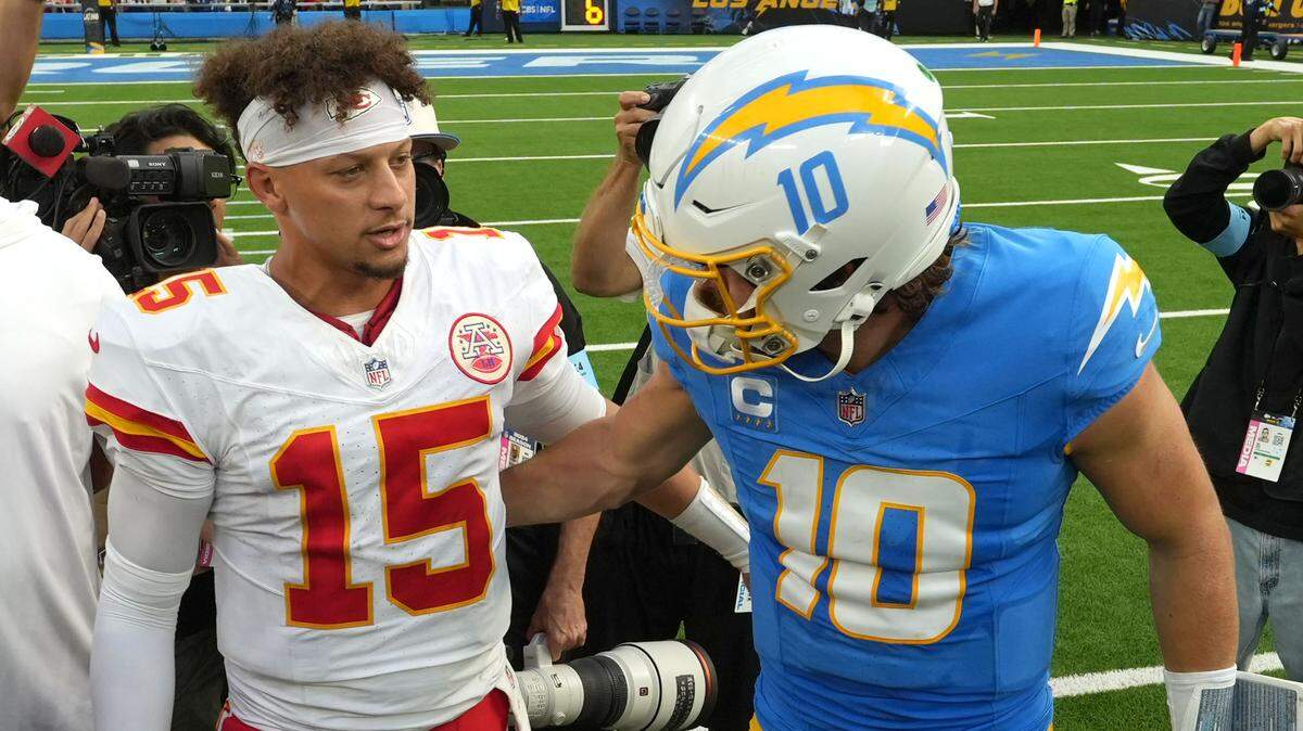 Kansas City Chiefs quarterback Patrick Mahomes (15) and Los Angeles Chargers quarterback Justin Herbert (10) shake hands after a game at SoFi Stadium.