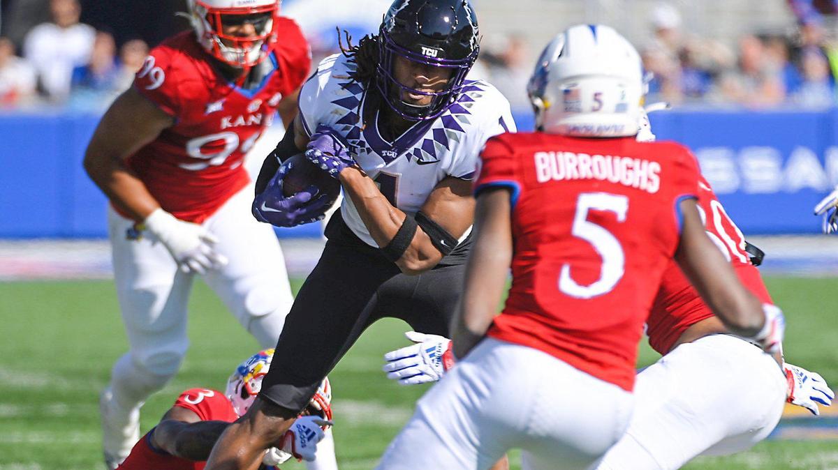 TCU Horned Frogs wide receiver Quentin Johnston is brought down by Kansas defenders in the first half Saturday, October 8, 2022, at David Booth Memorial Stadium in Lawrence, Kansas.