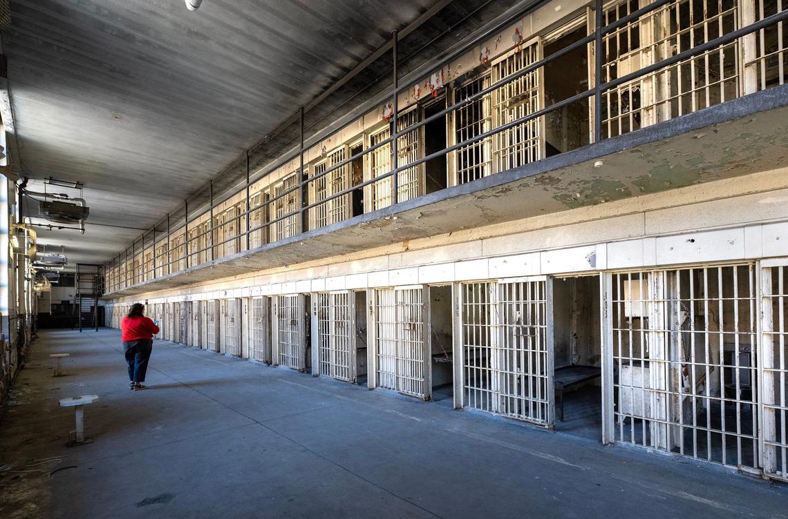 Lisa Snodgrass of the Lansing Historical Society and Museum walks down the row of prison cells in Cell Block C at the Lansing Correctional Facility during a tour on Monday.