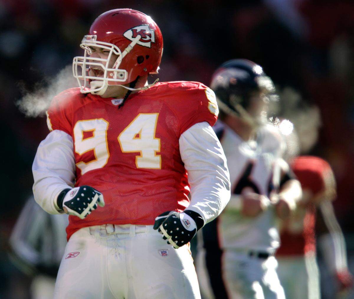 Junior celebrates after dropping running back Tatum Bell for a loss during the second quarter of a December 2004 game against the Denver Broncos.