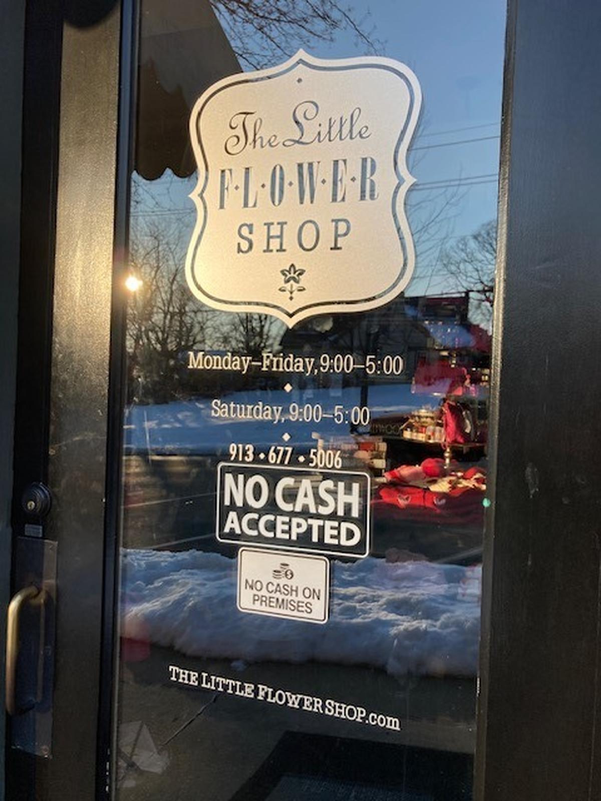 “No cash accepted” and “No cash on premises” signs mark the door of The Little Flower Shop in Westwood Hills.