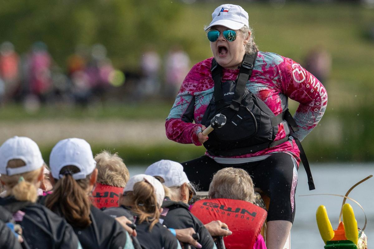 A drummer from Life is Bliss/Pink Phurree leads their team in a qualifying race during the KC Dragon Boat Festival on Saturday, Sept. 28, 2024, at Shawnee Mission Park.