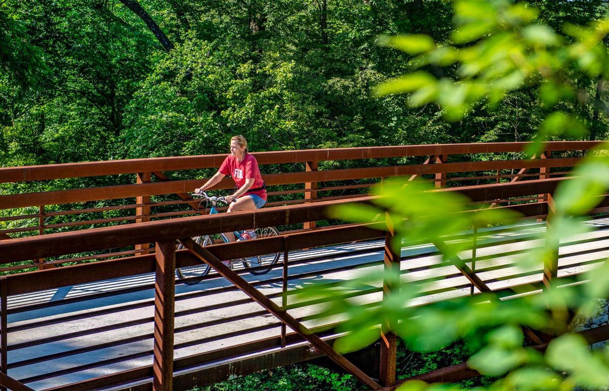 A cyclist rides the Rock Island Trail head, Monday, July 5, 2021 in Kansas City. A ceremony for the completion of the Rock Island Trail will be held at 10 a.m. Saturday, July 10, 2021 at the northernmost trailhead in parking lot L of the Truman Sports Complex.