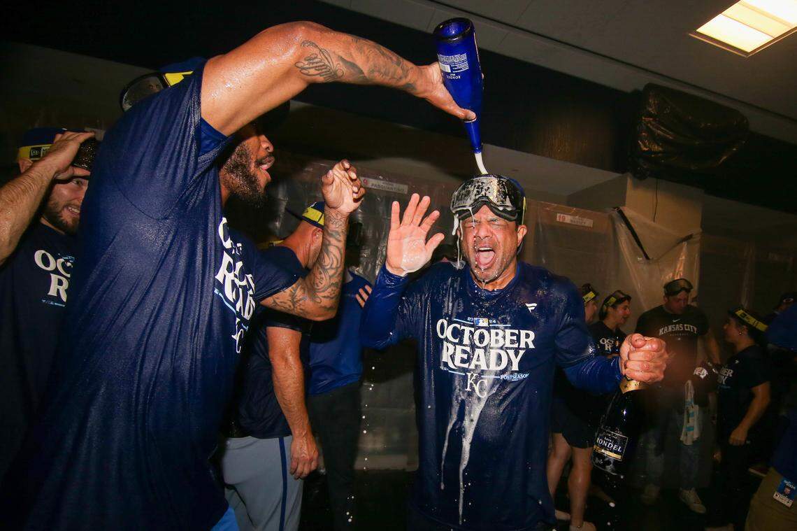 Kansas City Royals third baseman Maikel Garcia (11) and coach Miguel Garcia (82) celebrates after clinching a wild card playoff birth after a game against the Atlanta Braves at Truist Park.