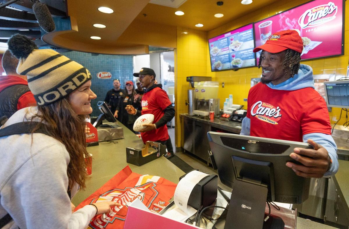 Kansas City Chiefs cornerback L’Jarius Sneed takes the order of a fan with working the counter at a Raising Cane’s restaurant in Blue Springs on Tuesday. Sneed was joined by teammate Mecole Hardman Jr., at the event.