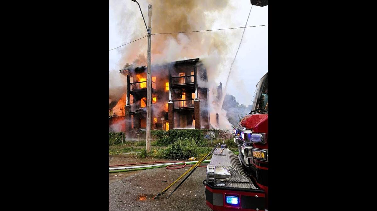 Kansas City firefighters responded to a two-alarm fire at 35th Street and Euclid Avenue Friday morning that engulfed a three-story vacant apartment building, and damaged a neighboring home.