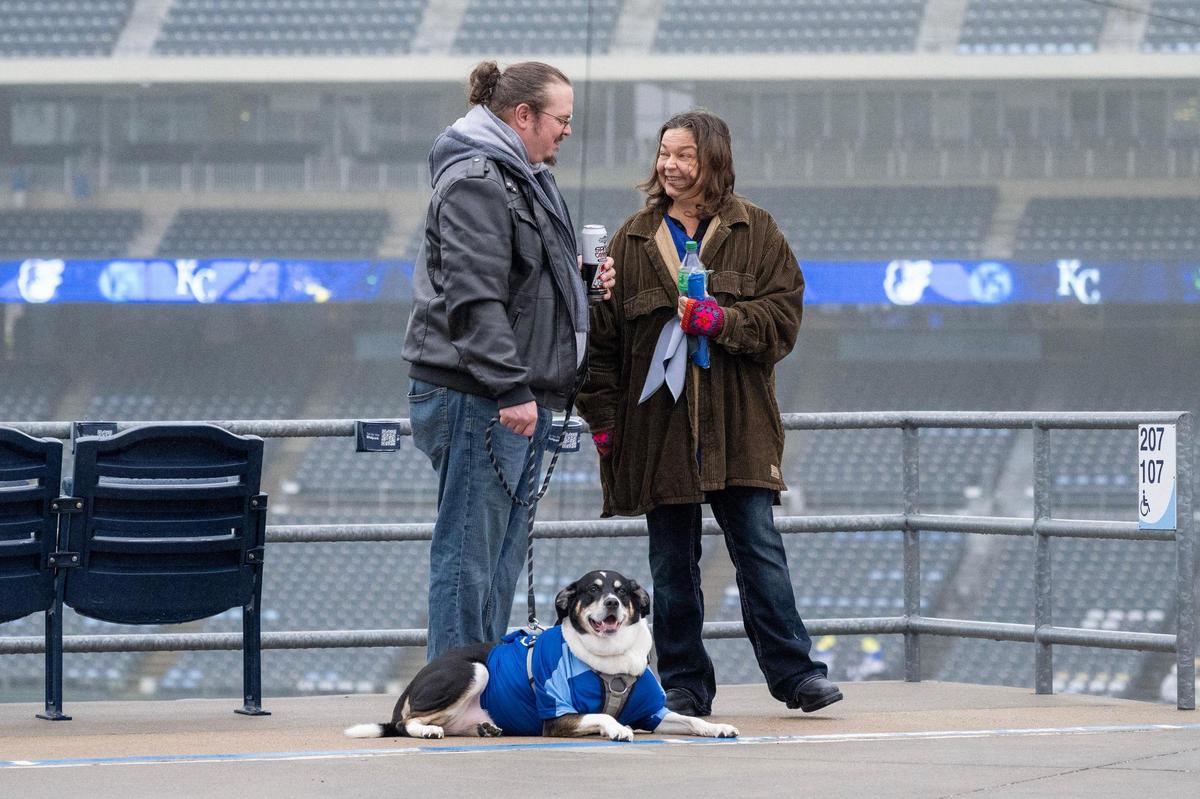 Nancy Rosen and Brant Rosen smile as they stand with their dog, Castiel, during Bark at the Park at an MLB game between the Kansas City Royals and the Baltimore Orioles on Friday, April 4, 2025, at Kauffman Stadium.