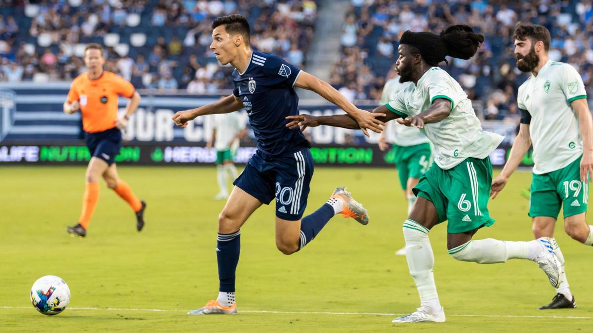 Sporting Kansas City forward Dániel Sallói (No. 20) maneuvers past Colorado Rapids defender Lalas Abubakar for the opening goal of Wednesday night’s match at Children’s Mercy Park in Kansas City, Kansas.