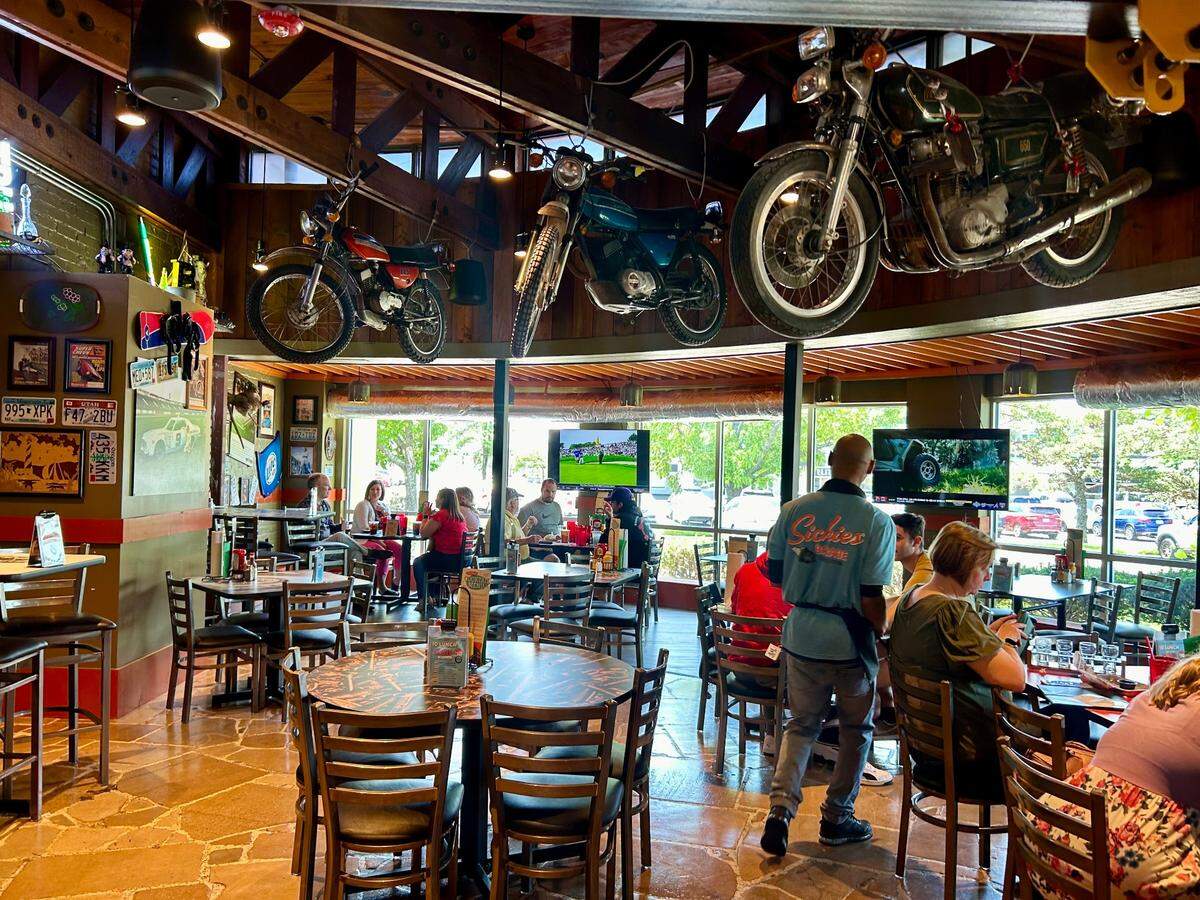 Motorcycles hang from the ceiling of Sickies Garage in Overland Park. The burger and brews restaurant opened this week.