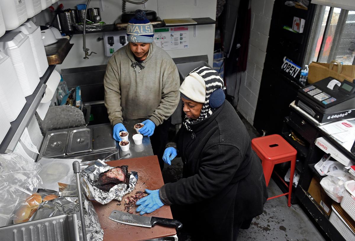 Inside the tiny building that is Jones BBQ, co-owner Deborah Jones is assisted by her nephew Leavy Jones in preparing baked beans with burnt ends. The restaurant is located at 6706 Kaw Drive in Kansas City, Kansas.