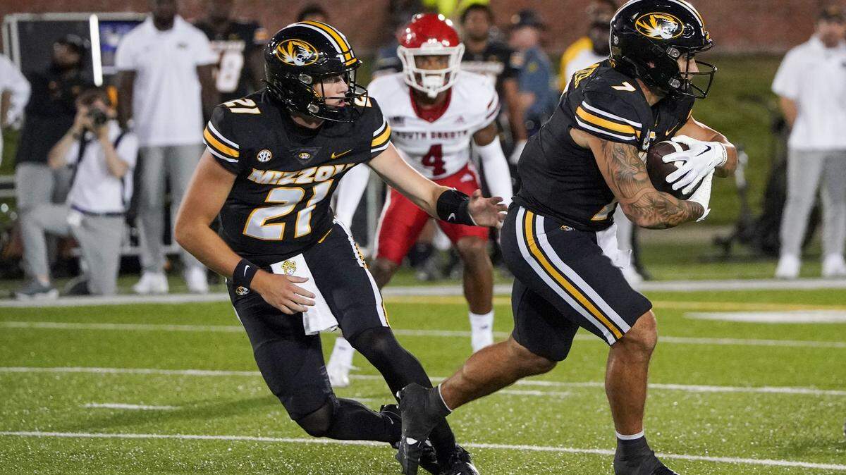 Missouri Tigers quarterback Sam Horn (21) handed off to running back Cody Schrader (7) against the South Dakota Coyotes during the first half at Faurot Field at Memorial Stadium.