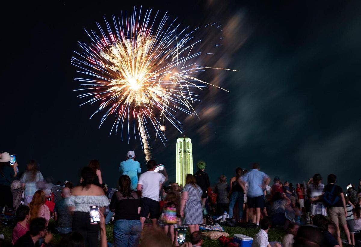 People watch and record fireworks as they explode over the Liberty Memorial and the National World War I Museum at the end of the Celebration at the Station, an event featuring the Kansas City Symphony to celebrate and commemorate Memorial Day on Sunday, May 29, 2022, in Kansas City.