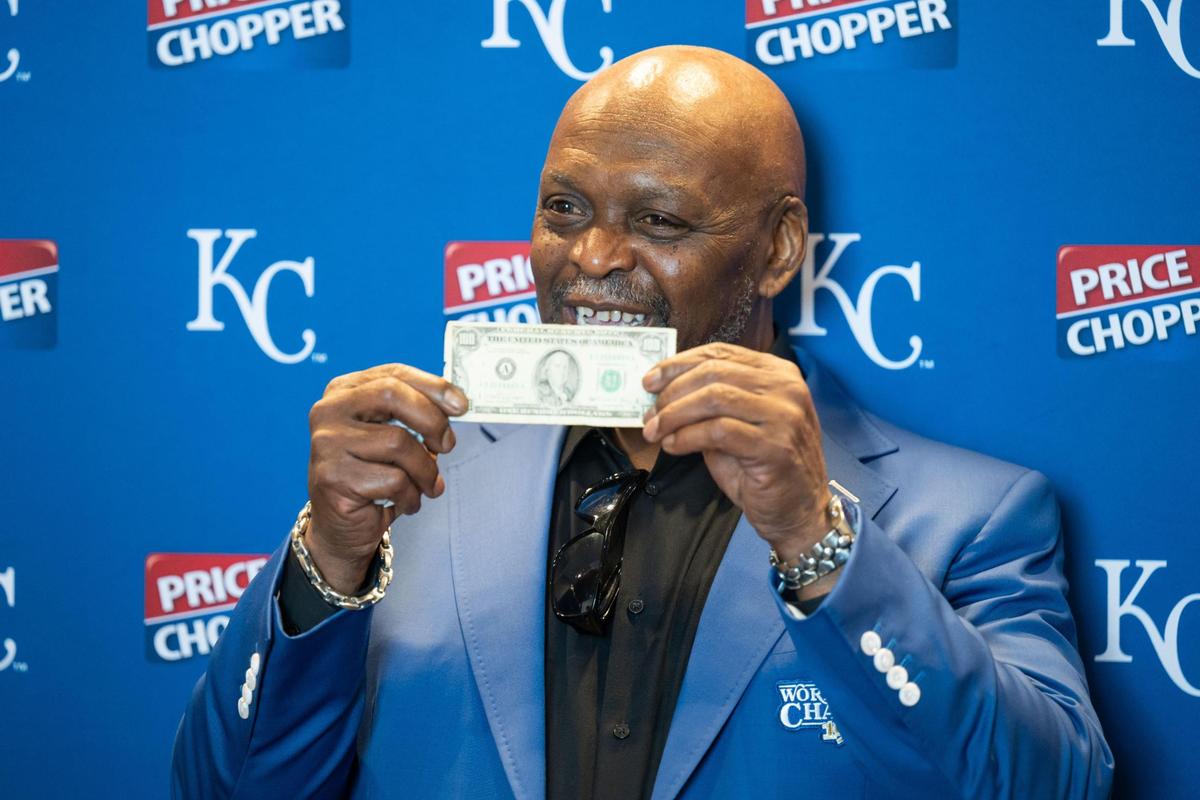 Former Kansas City Royals outfielder Darryl Motley holds up a $100 bill given to him by George Brett while speaking with media at the Loews Hotel prior to the Champions Gala on Thursday, May 15, 2025. Motley, who played for the Royals on the 1985 championship team, caught the last out in the deciding game of the championship series.