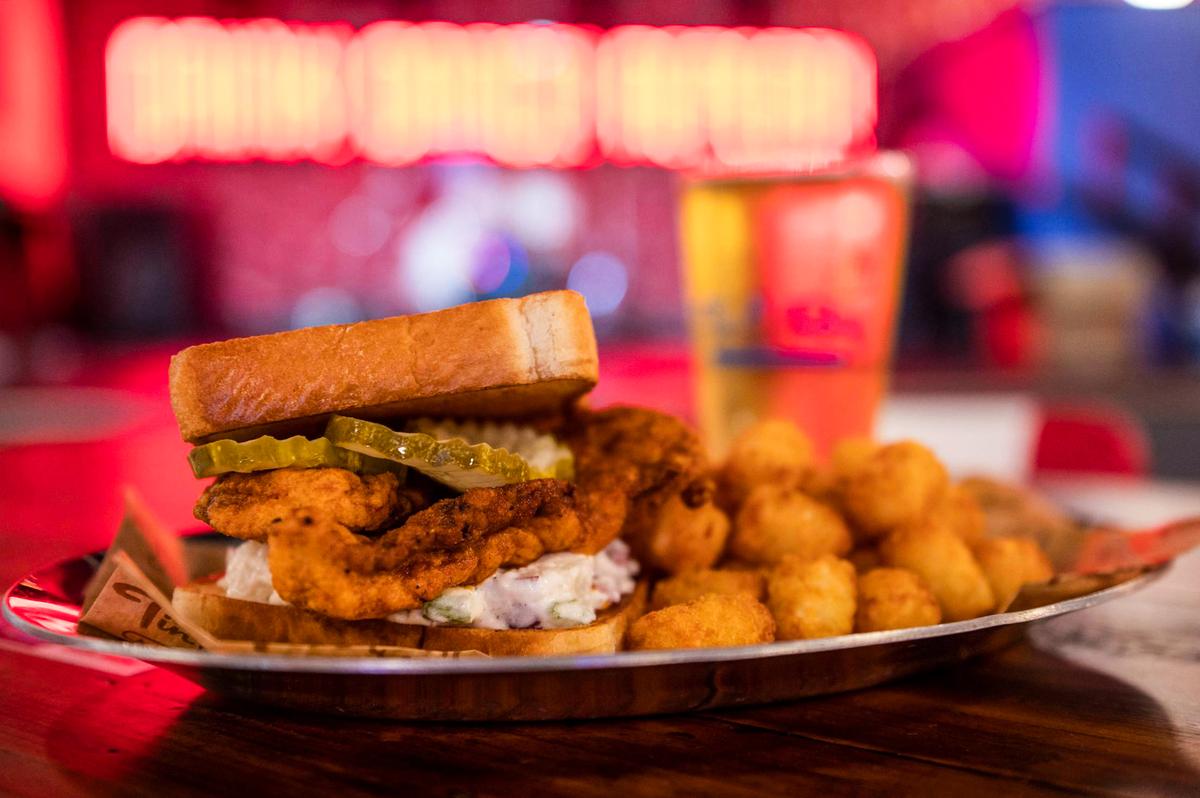 One of Tin Roof’s most popular menu items is the Nashville hot chicken sandwich, served with tater tots.
