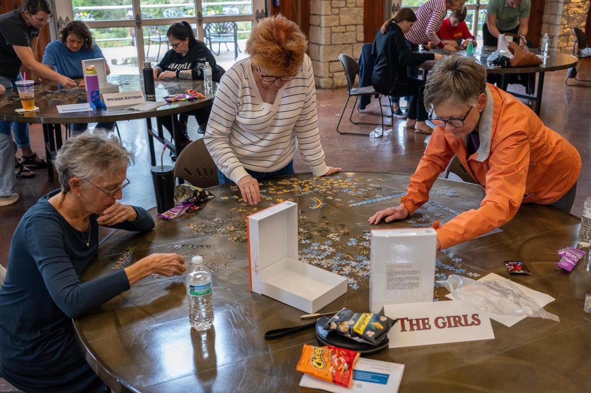 The Girls puzzle team works on completing a 500-piece puzzle during the Puzzle Palooza competition.