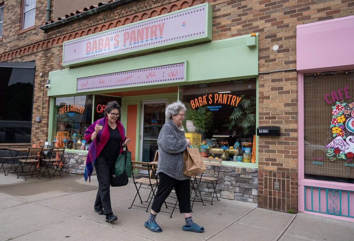 Mercedes Bern-Klug, left, and her sister, Robin Scoblic, leave Baba's Pantry in Kansas City on Tuesday, May 19, 2026, with bags of food, including a large bottle of Palestinian olive oil. Bern-Klug, visiting from Iowa City, Iowa, extended her trip by a day just to wait for the pantry to open so she could purchase the oil.