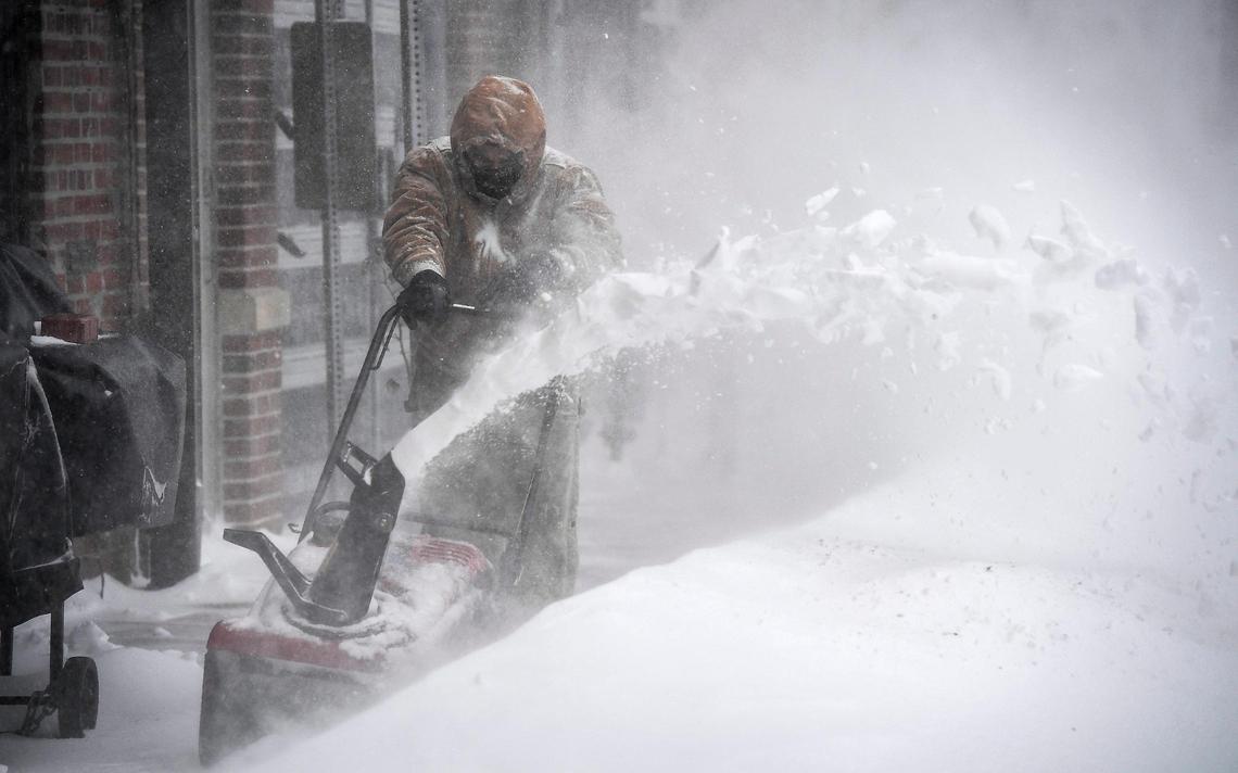 Windblown snow engulfs Izzy Licos while he uses a snow blower to clear a drift from the sidewalk of a business on Jan. 5, 2025, in downtown Overland Park. Blizzard conditions hit the Kansas City metro crippling transportation and shutting down several businesses.