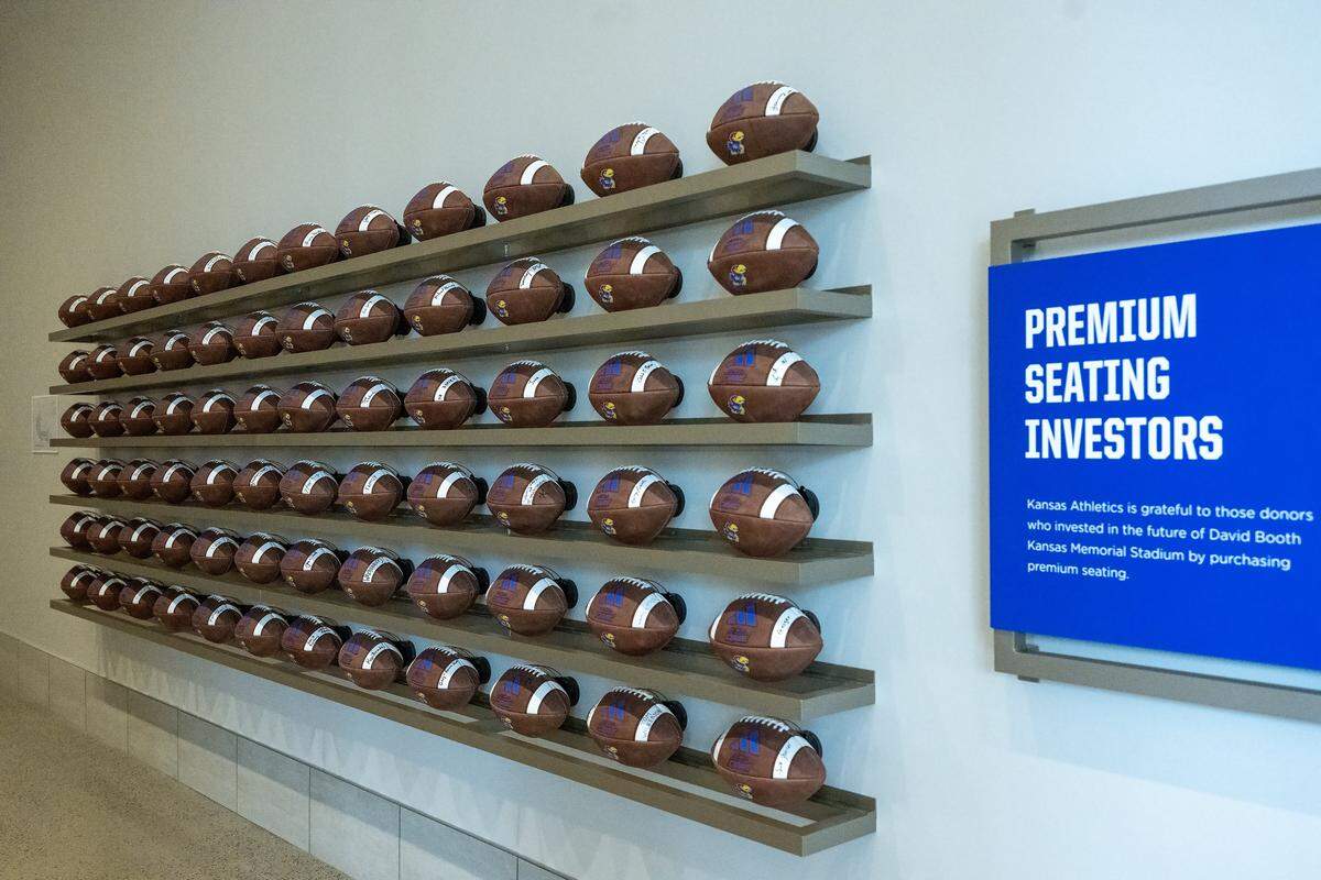 Footballs line the wall in an area for Premium Seating Investors at the new David Booth Kansas Memorial Stadium.