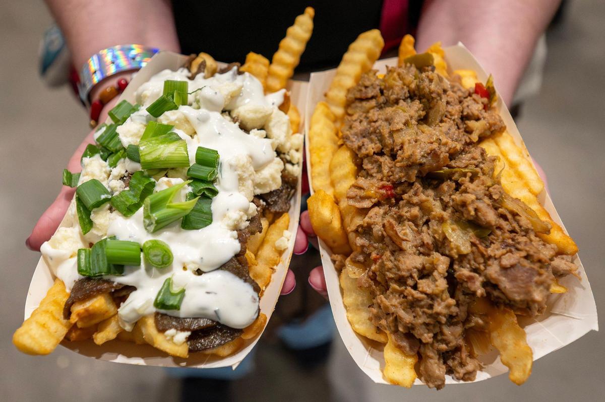 An attendee showcases crinkle-cut fries with toppings during Planet Comicon at the Kansas City Convention Center on Saturday, March 22.